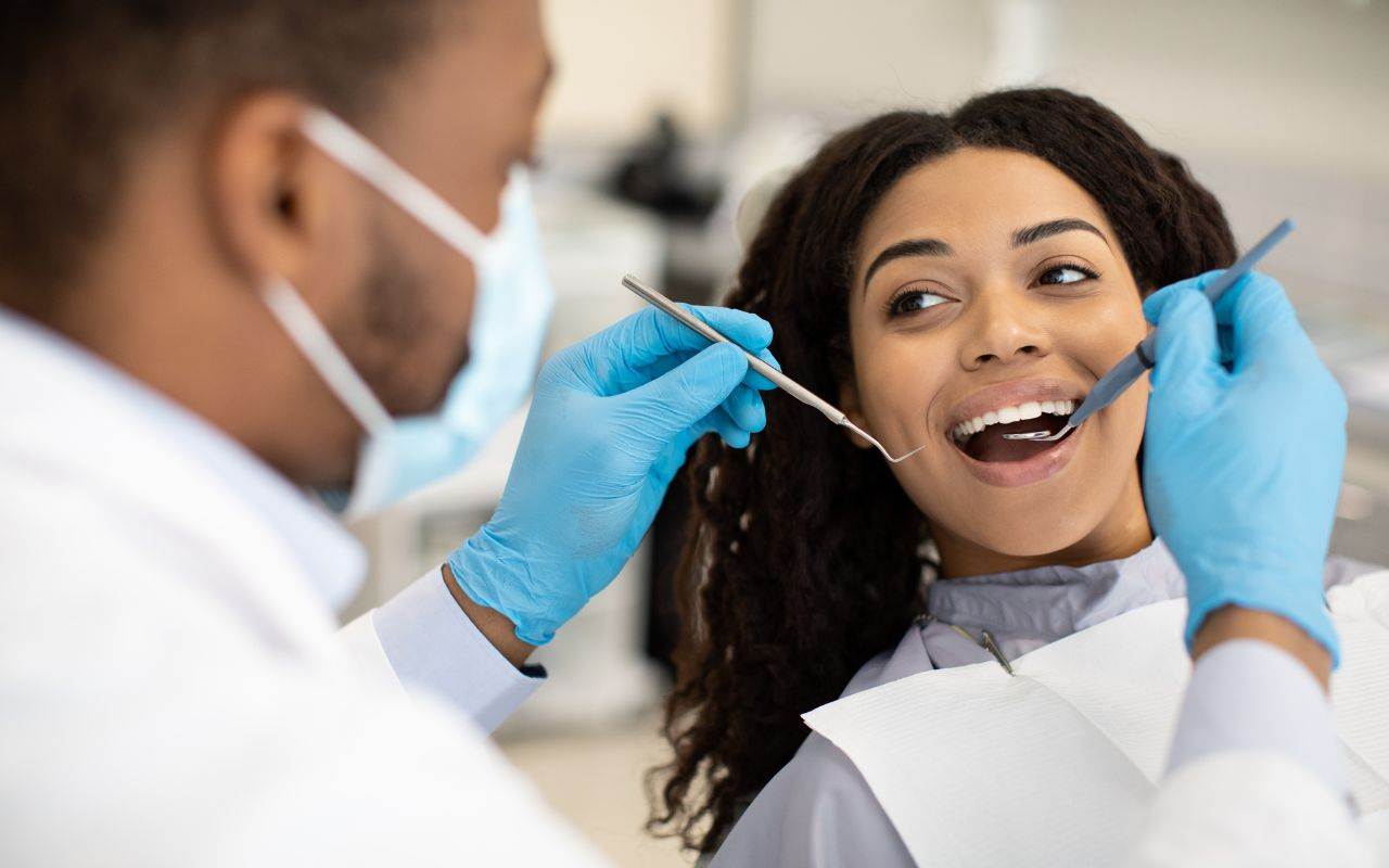 A woman is getting her teeth cleaned to maintain her dental health.