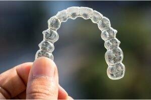 man holding Invisalign braces