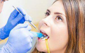 A woman is visiting a dentist for a teeth check-up to prevent gum disease.