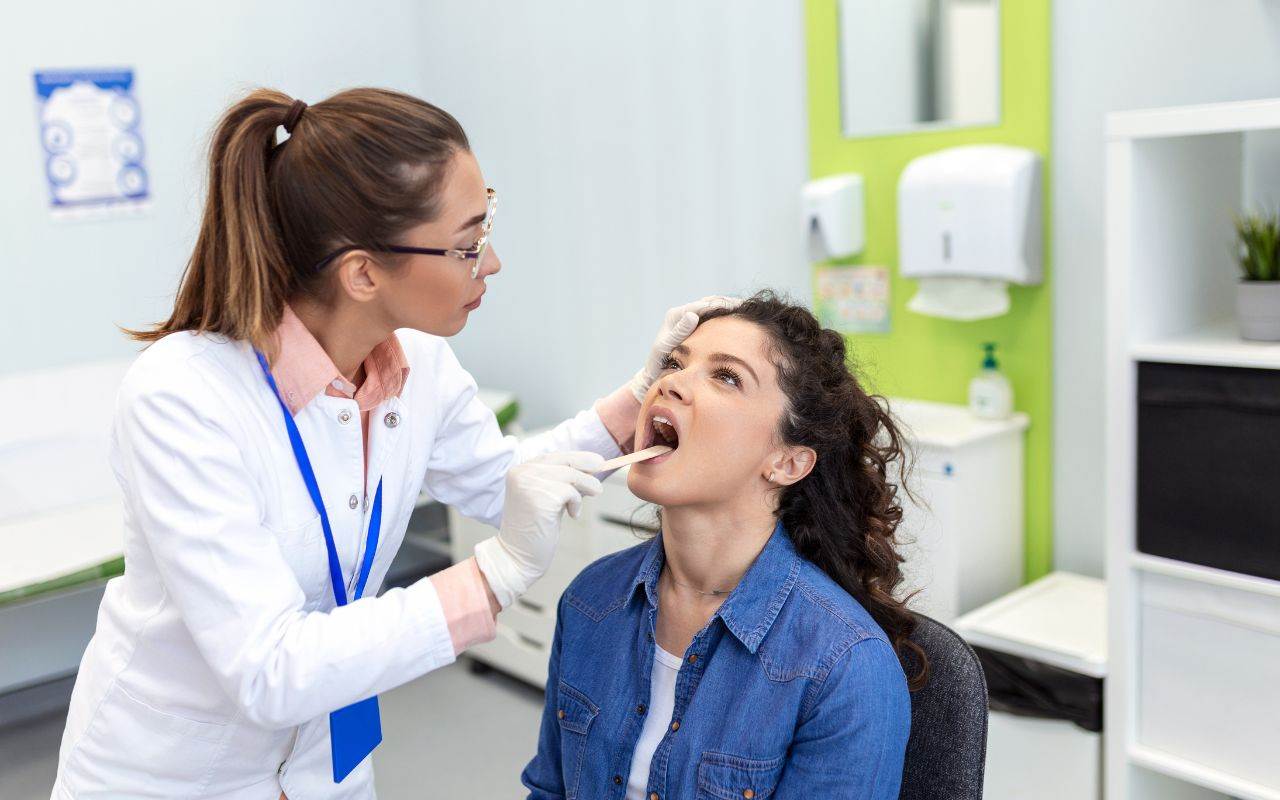 how-do-vitamins-and-minerals-affect-teeth - A woman getting her throat checked