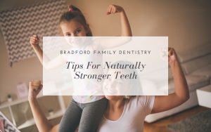 Child sitting on an adult's shoulders and flexing arm muscles with both smiling; overlay text reads, "Bradford Family Dentistry - Tips for Naturally Stronger Teeth.